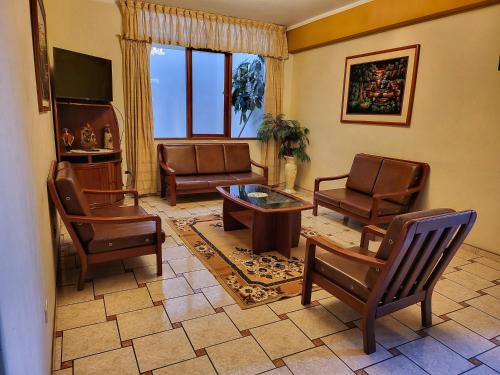 a living room with leather chairs and a table at D'Cardenas Hotel in Cajamarca