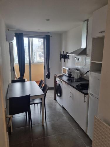 une cuisine avec une table et une table ainsi qu'une salle à manger dans l'établissement F3 ,appartement climatisé neuf, magnifique vue sur mer et aéroport, proche tram et gare sncf 1 min,aéroport 3 minutes, 3 rooms, new AC apartment, magnificent sea and airport views, close to tram and SNCF train station 1 min, airport 3 min, à Nice