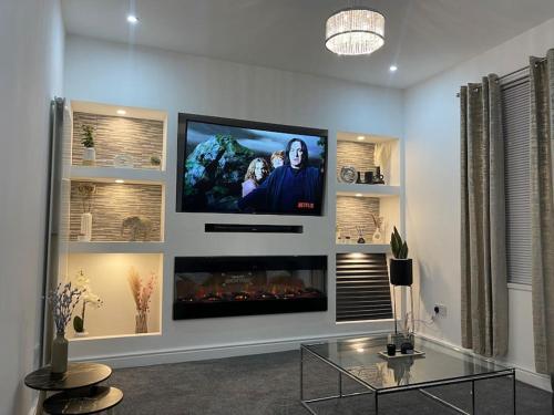 a living room with a flat screen tv on a wall at NEW Modern 5 Bedroom House - City Centre - Parking in Cardiff