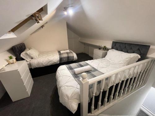 a bedroom with two beds and a crib at NEW Modern 5 Bedroom House - City Centre - Parking in Cardiff