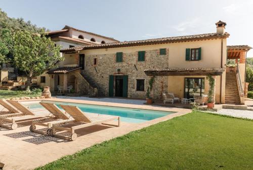 a villa with a swimming pool in front of a house at Il Mulino di Nonna Sà - Prestige Private Villa in Pietrasanta