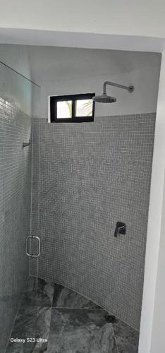 a bathroom with a shower with a window at Alborada Boutique Stay in Uvita