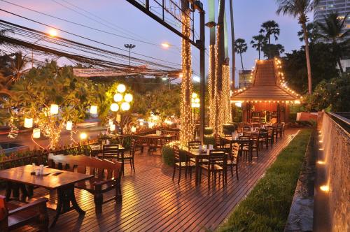 a restaurant with tables and lights on a deck at night at Jomtien Palm Beach Hotel & Resort - Family-Friendly in Jomtien Beach