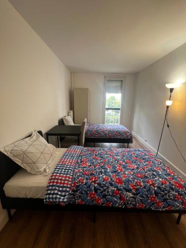 une chambre avec un lit avec une couverture dessus dans l'établissement Single bed in a 2 bed dormitory room near Paris, à Argenteuil