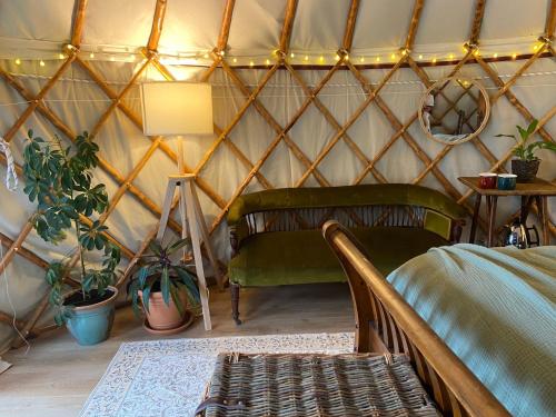 a room with a bed and plants in a yurt at Nature Cabins Hiigher Farm in Ditcheat