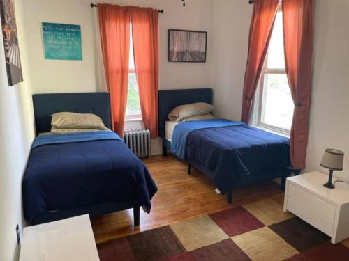 two beds in a room with two windows at The Pearl-Lovely Victorian Home with Bed and Breakfast Energy in West Bergen