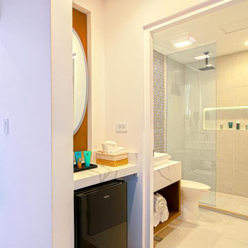 a bathroom with a sink and a toilet and a mirror at Bellafer Collection Hotel & Resort in Rosarito