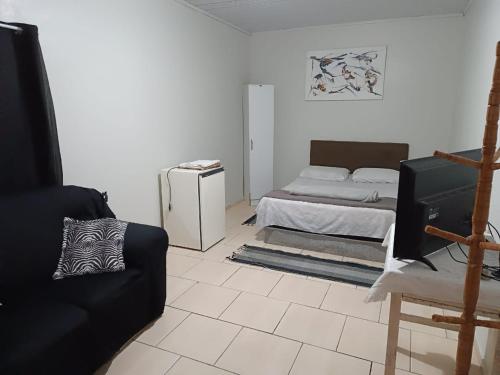 a living room with a bed and a couch at Pousada Paradise in Rio Grande