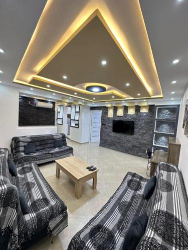 a living room with two beds and a tv at Appartements équipés luxe in Mansoûra