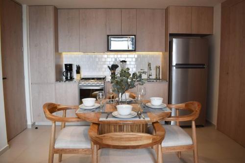 a kitchen with a table with chairs and a refrigerator at Nuevo Depa con increible vista en YU Country 1804 in Guadalajara