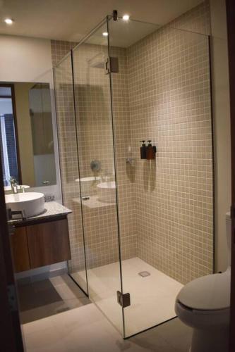 a bathroom with a shower with a toilet and a sink at Nuevo Depa con increible vista en YU Country 1804 in Guadalajara