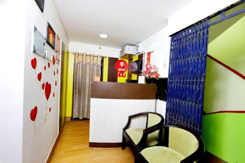 una habitación con una silla y una pared con corazones en Hotel O India Gate Par View, en Chennai