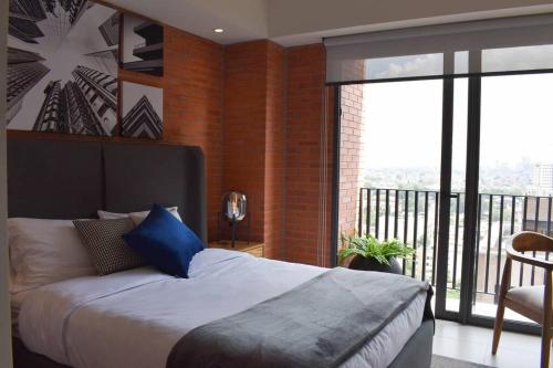 a bedroom with a large bed and a balcony at Nuevo Loft con increible vista en YU Country 1506 in Guadalajara