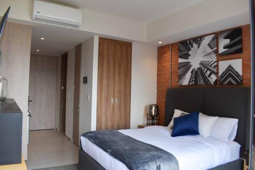 a bedroom with a large bed with blue pillows at Nuevo Loft con increible vista en YU Country 1506 in Guadalajara