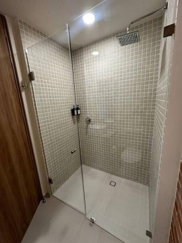 a shower with a glass door in a bathroom at Nuevo Loft con increible vista en YU Country 1506 in Guadalajara