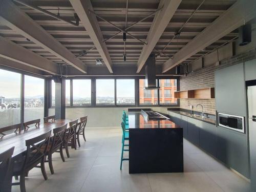 a large kitchen with a long table and chairs at Nuevo Loft con increible vista en YU Country 1506 in Guadalajara