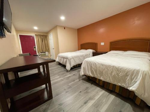 a hotel room with two beds and a table at Travelers Motor Lodge in North Smithfield