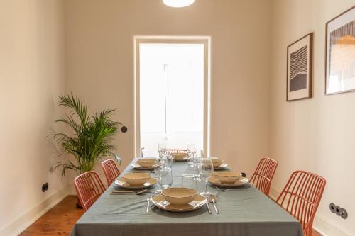 a dining room with a table with plates and wine glasses at Alvalade 58 - Charming 2 bedroom apartment with AC near the airport and city center in Lisbon