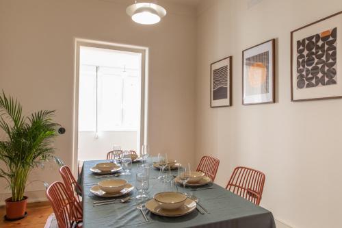a dining room with a blue table and chairs at Alvalade 58 - Charming 2 bedroom apartment with AC near the airport and city center in Lisbon