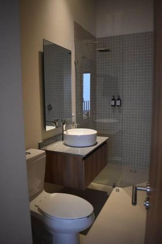 a bathroom with a toilet and a sink and a mirror at Nuevo Penthouse con la mejor vista de Guadalajara 2501 in Guadalajara