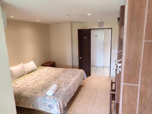 a bedroom with a bed and a door to a room at Ashly Boulevard in Acapulco
