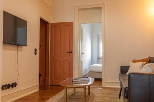 a living room with a couch and a table at Alvalade 58 - Charming 2 bedroom apartment with AC near the airport and city center in Lisbon