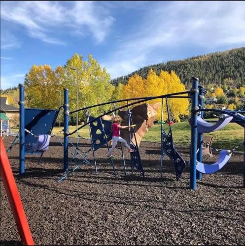 a young girl is playing on a playground at Ski And Golf Condo - 9 Min To Vailbc in Avon