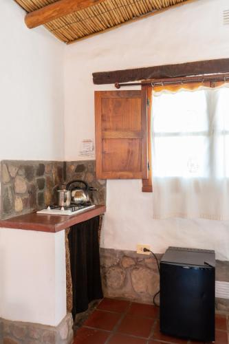a kitchen with a counter and a sink and a window at Hosteria La Morada in Tilcara