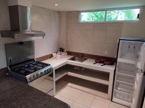 a small kitchen with a stove and a sink at Ashly Boulevard in Acapulco