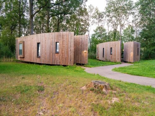 two wooden houses in a field with a path at Idyllic Couple s Cottage in Antoing
