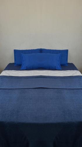 a blue bed with blue pillows on top of it at Descubra seu novo espaço preferido em Americana-SP in Americana
