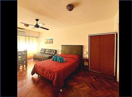 ein Schlafzimmer mit einem roten Bett und einer Couch in der Unterkunft Corrientes Av, Premium Location in Buenos Aires