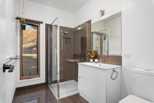 a bathroom with a white sink and a shower at The Good House in Kiewa