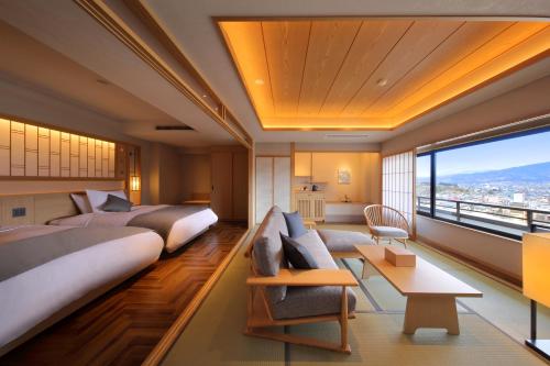 a hotel room with two beds and a large window at Hotel Koyo in Kaminoyama