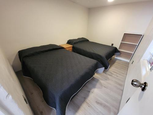 two beds in a room with a door open at Casa Dali in San Felipe del Agua