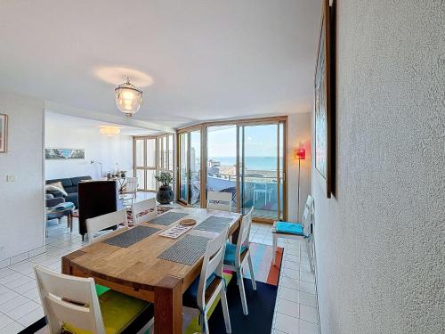 une salle à manger avec une table et des chaises en bois dans l'établissement Appartement lumineux avec ascenseur, balcon et wifi gratuit à Granville - FR-1-361-123, à Granville