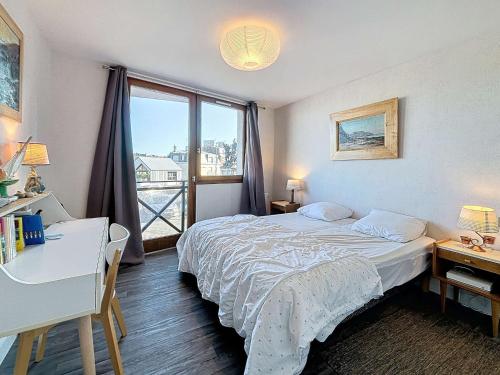 une chambre avec un lit, un bureau et une fenêtre dans l'établissement Appartement lumineux avec ascenseur, balcon et wifi gratuit à Granville - FR-1-361-123, à Granville