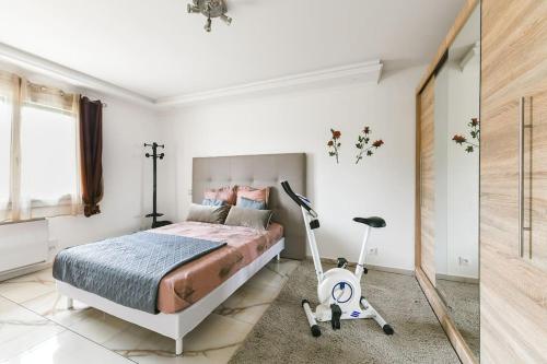 - une chambre avec un lit et un aspirateur dans l'établissement L'Elégante Etoile Parisienne avec Terrasse - Proche Gare et Seine, aux Mureaux