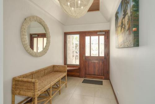 a hallway with a bench and a mirror and a door at Puunoa Beach Estates 103 in Lahaina