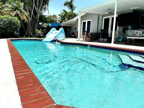 a swimming pool with a slide in a house at Pool House Resort heated swimming pool private duplex in Cutler Bay