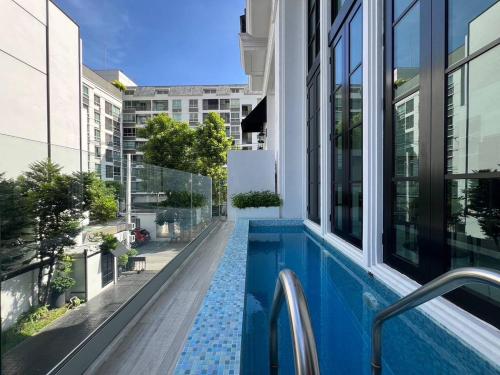 a swimming pool on the side of a building at Luxury Pool Villa 5BR 12pax with Private Lift in Ekkamai in Bangkok