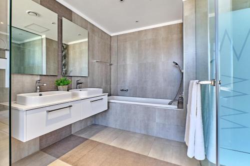 a bathroom with a sink and a tub and a shower at Masingita Towers Hotel, Luxurious Sunset Condo in Johannesburg