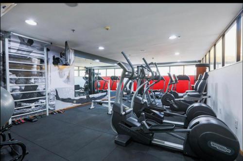 a gym with rows of tread machines and red chairs at Luxuoso Flat No Hotel Radisson EXCELENTE LOCALIZAÇÃO in Belém