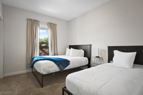 two beds in a room with a window at Spacious 6BR less than 10 min walk to DT WI Dells! in Wisconsin Dells