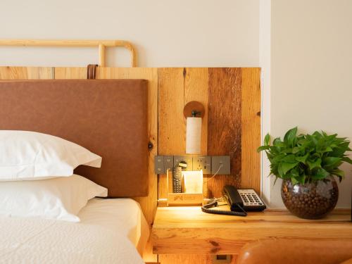 a bedroom with a bed and a phone and a plant at Patio Spring Holiday Inn -- Free round trip pick-up service --Panoramic view of Tianmen Mount in Zhangjiajie