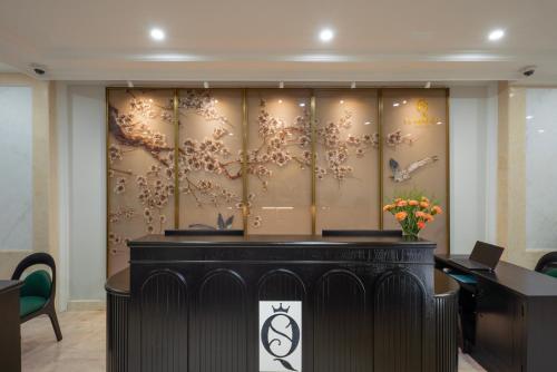 a lobby with a desk and a wall with flowers at SQ Hang Gai Hotel & Spa in Hanoi