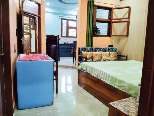 a room with a bed and a table and a couch at Doon Niwas Homestay 2-Bedroom 1st Floor- Mountain view, near main Picnic Spots, comfortable peaceful central Family-friendly in Dehradun