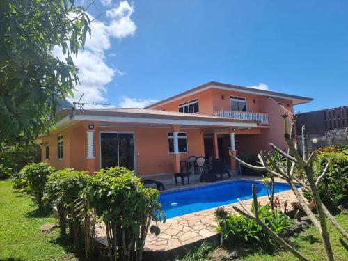 a house with a swimming pool in front of it at Moemoea Nui Villa in Apomaoro