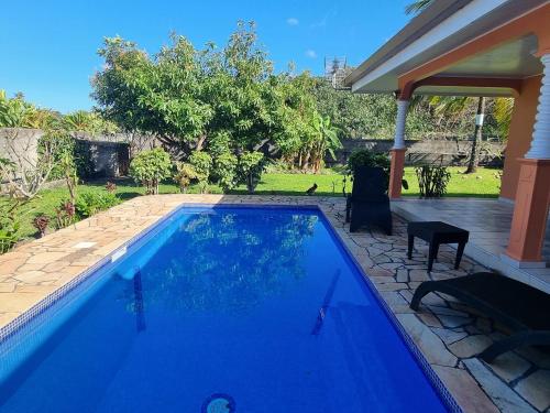 a swimming pool in the backyard of a house at Moemoea Nui Villa in Apomaoro