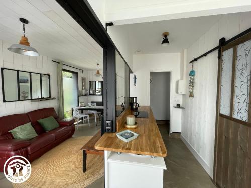 un salon avec un canapé et une table dans l'établissement Maison rénovée proche plage avec cour privative, vélos et équipements bébé - FR-1-426-561, à Les Sables-dʼOlonne